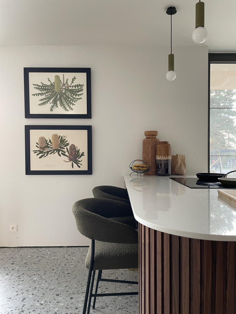 Keuken met twee schilderijen en stoelen aan ontbijtbar