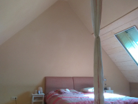 slaapkamer onder het dak, met houten planken aan het raam en geleemd (Claytec) aan de muren heel goede vochtregulatie